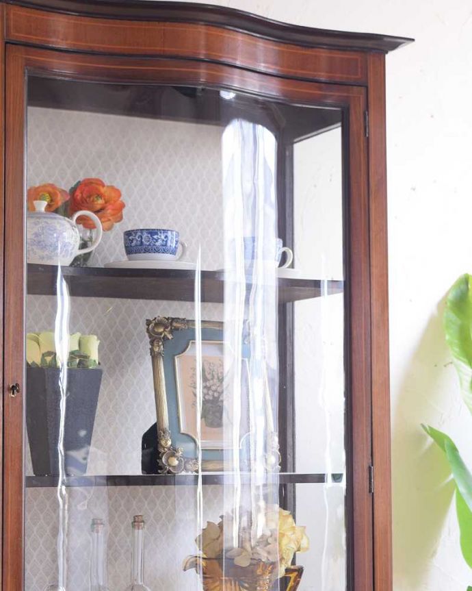 アンティークのキャビネット　アンティーク家具　ガラスの曲線が美しい優雅なアンティークキャビネット（凸ガラス）。現代でもなかなか作れない湾曲ガラスアンティークのガラスを通して中に入っているものを見ると、なんだかちょっと高級に見えるんです。(k-2094-f)