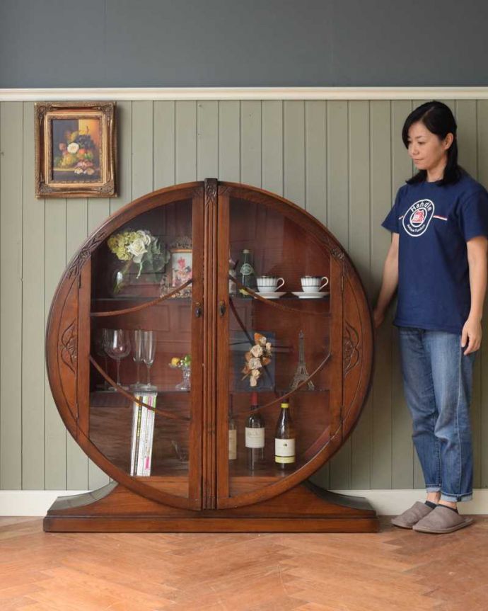 アンティークのキャビネット　アンティーク家具　英国で見つけたお花の彫りが美しい中々出会えない丸いアンティークキャビネット。おススメNo.1のアンティーク家具もともとチャイナキャビネットとして陶器を見せながら収納するために造られたガラスの扉のキャビネット。(k-2095-f)