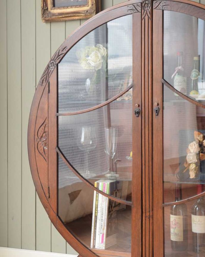 アンティークのキャビネット　アンティーク家具　英国で見つけたお花の彫りが美しい中々出会えない丸いアンティークキャビネット。ガラス越しに見るお気に入りの美しさ…光をたっぷり取り入れてくれるガラス扉と棚板。(k-2095-f)