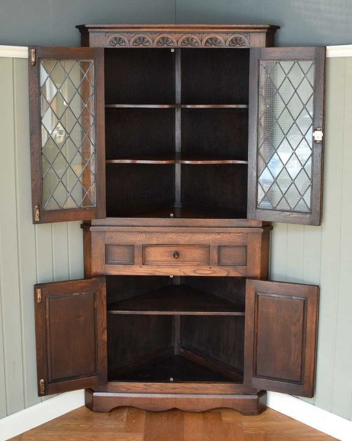 アンティークのキャビネット アンティーク家具 お部屋の角を彩るアンティーク家具、お花の彫刻が華やかなガラス扉のコーナーキャビネット。扉を開けてみると・・・専門の職人がしっかり修復していますので、扉の中はピカピカです。(k-2103-f)