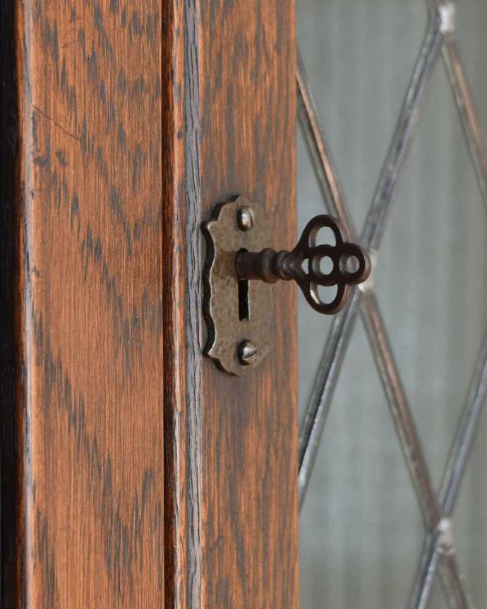 アンティークのキャビネット アンティーク家具 お部屋の角を彩るアンティーク家具、お花の彫刻が華やかなガラス扉のコーナーキャビネット。開ける度にワクワクアンティークらしい取っ手のデザイン。(k-2103-f)