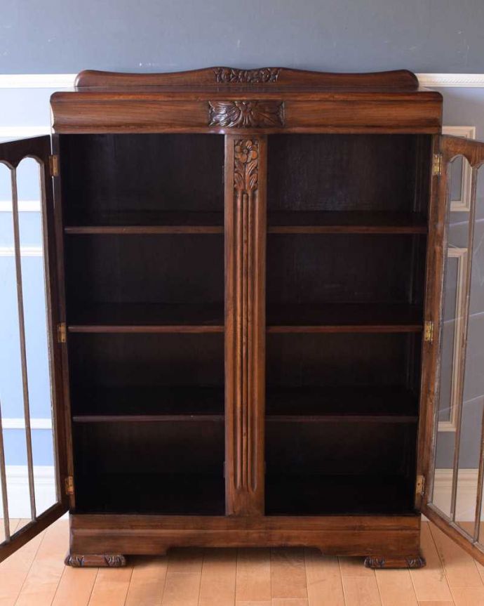 アンティークのキャビネット　アンティーク家具　お花の彫刻が華やか、英国の重厚なアンティークブックケース（ブックシェルフ）。扉の中は、しっかりと収納できる棚板重い本がたっぷり収納できるように頑丈に作られています。(k-2153-f)