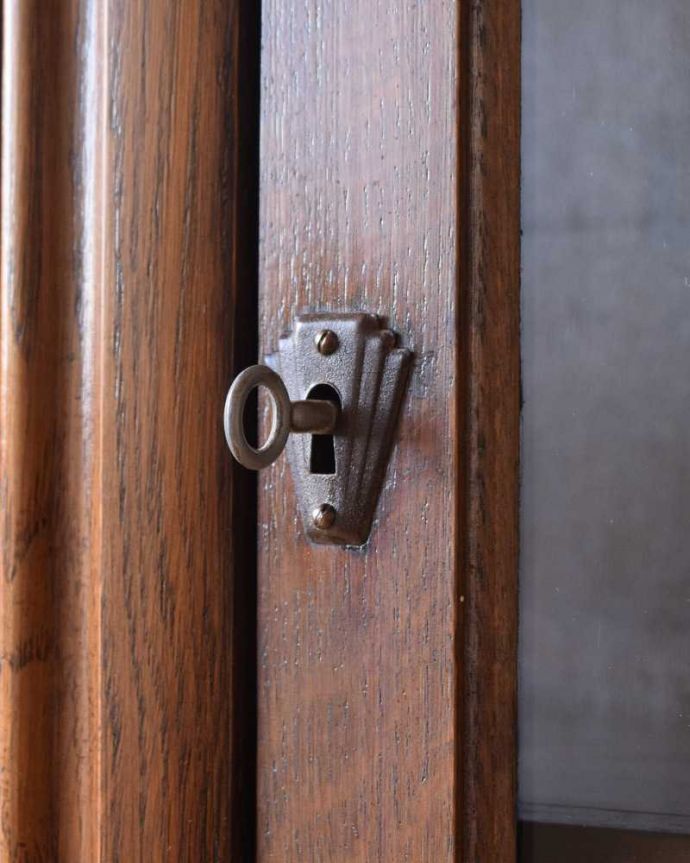 アンティークのキャビネット　アンティーク家具　お花の彫刻が華やか、英国の重厚なアンティークブックケース（ブックシェルフ）。開ける度にワクワクする取っ手鍵が取っ手になっているので、中を開ける度にまるで宝箱を開ける気分です。(k-2153-f)