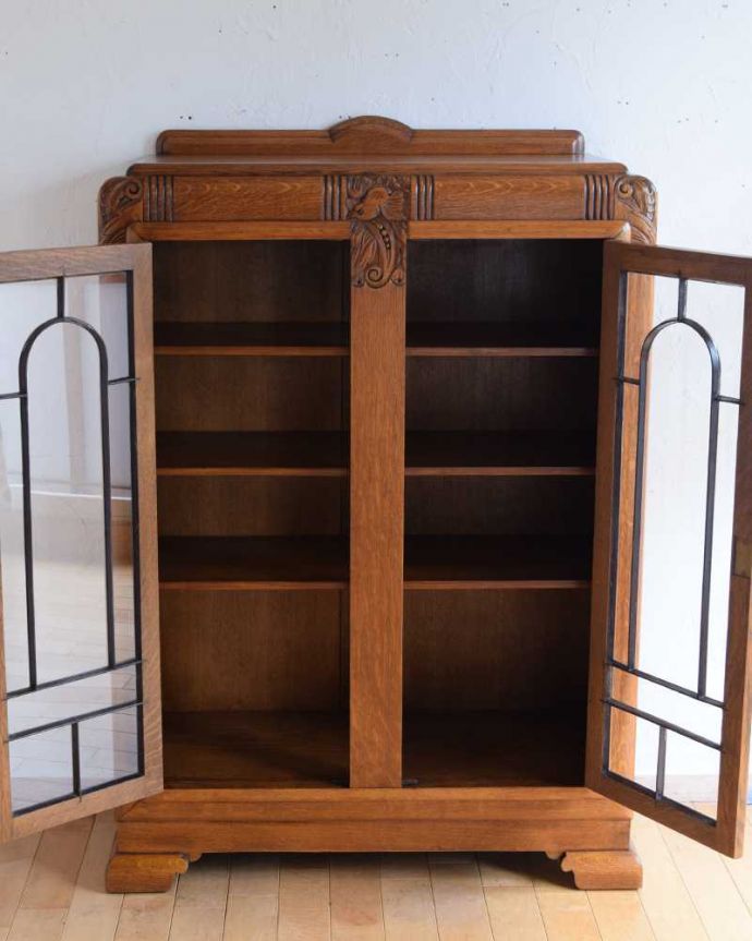 アンティークのキャビネット　アンティーク家具　イギリスから届いたアンティーク家具、凛々しい鳥が守ってくれる美しい木製のブックケース（本棚）。扉の中は、しっかりと収納できる棚板重いものもたっぷり収納できる木製の棚板タイプ。(k-2260-f)