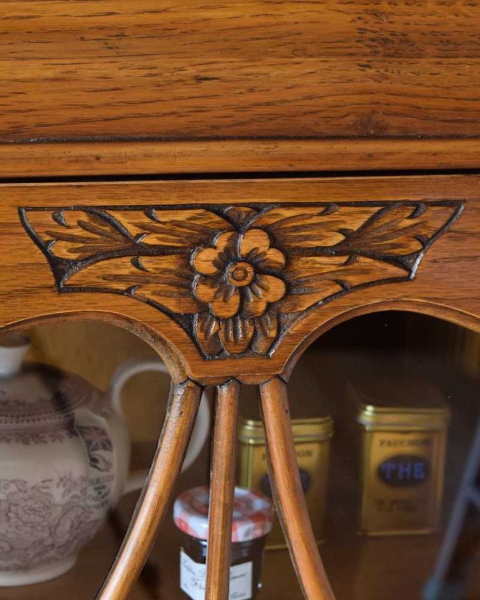 アンティークのキャビネット　アンティーク家具　イギリスアンティークの収納家具、お花の彫刻入りのブックケース（キャビネット）。いろんな場所にこだわり彫のデザインもいろいろです。(k-2319-f)