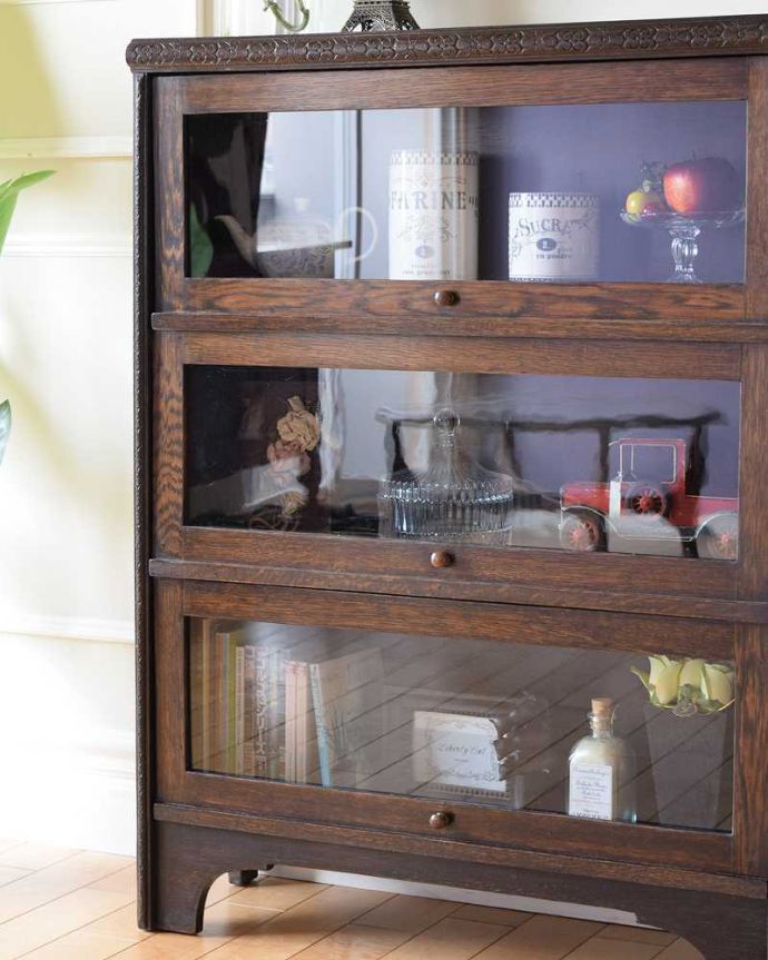 アンティークのキャビネット　アンティーク家具　小さくて置きやすいフラップ扉のブックケース、英国輸入のアンティークキャビネット 。ガラス越しに中をのぞいてみると･･･アンティークのガラスを通して中に入っているものを見ると、なんだかちょっと高級に見えるんです。(k-2324-f)