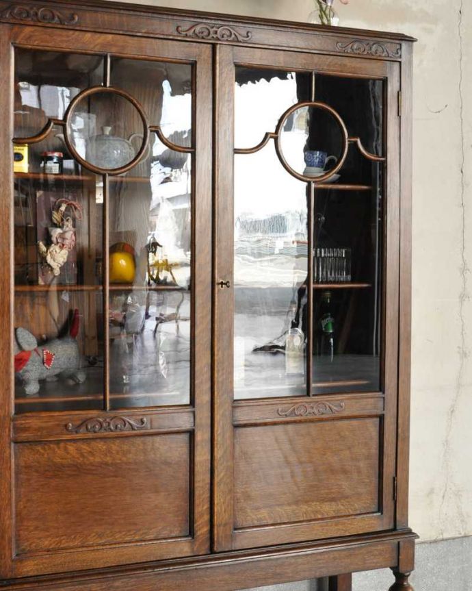 アンティークのキャビネット アンティーク家具 アンティーク英国輸入家具、ガラス扉のブックケース(本棚)。ガラス越しに中をのぞいてみると・・・アンティークのガラスを通して中に入っているものを見ると、なんだかちょっと高級に見えるんです。(k-2336-f)