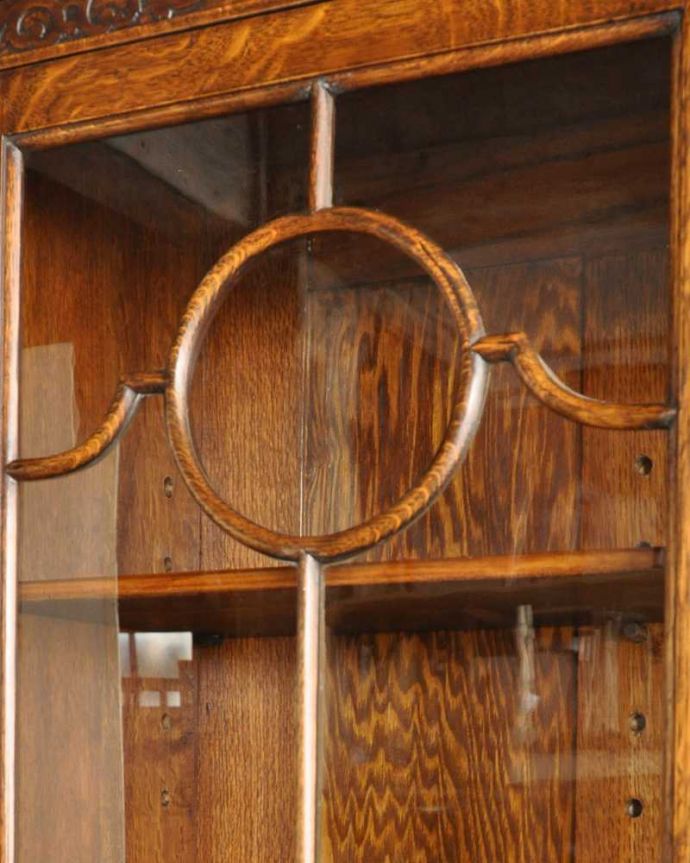 アンティークのキャビネット アンティーク家具 アンティーク英国輸入家具、ガラス扉のブックケース(本棚)。いろんな場所にこだわり彫のデザインもいろいろです。(k-2336-f)