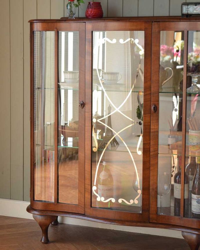 アンティークのキャビネット　アンティーク家具　英国輸入のアンティーク家具、ガラスの装飾も美しいミラー付きガラスキャビネット。ガラス越しに中をのぞいてみると･･･光りが入るとミラーに反射してキラッと輝くから、中に入れたものにまるでスポットライトが当たっているように見えちゃうんです。(k-2379-f)