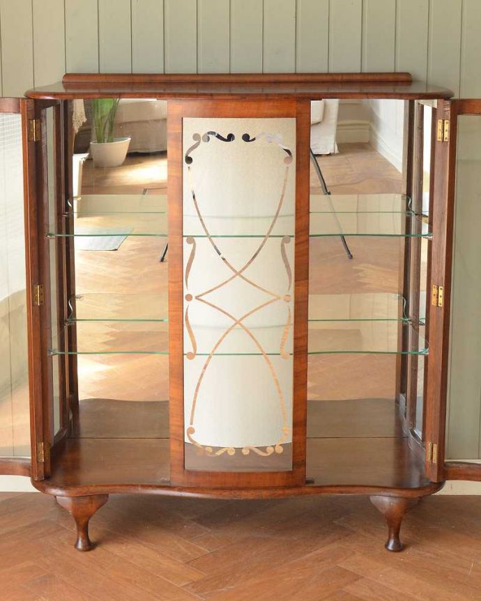 アンティークのキャビネット　アンティーク家具　英国輸入のアンティーク家具、ガラスの装飾も美しいミラー付きガラスキャビネット。ミラーの効果で、なんだか大きく見えます背板の鏡にキャビネット自身が映し出されて、大きな形のキャビネットに見えちゃうんです。(k-2379-f)