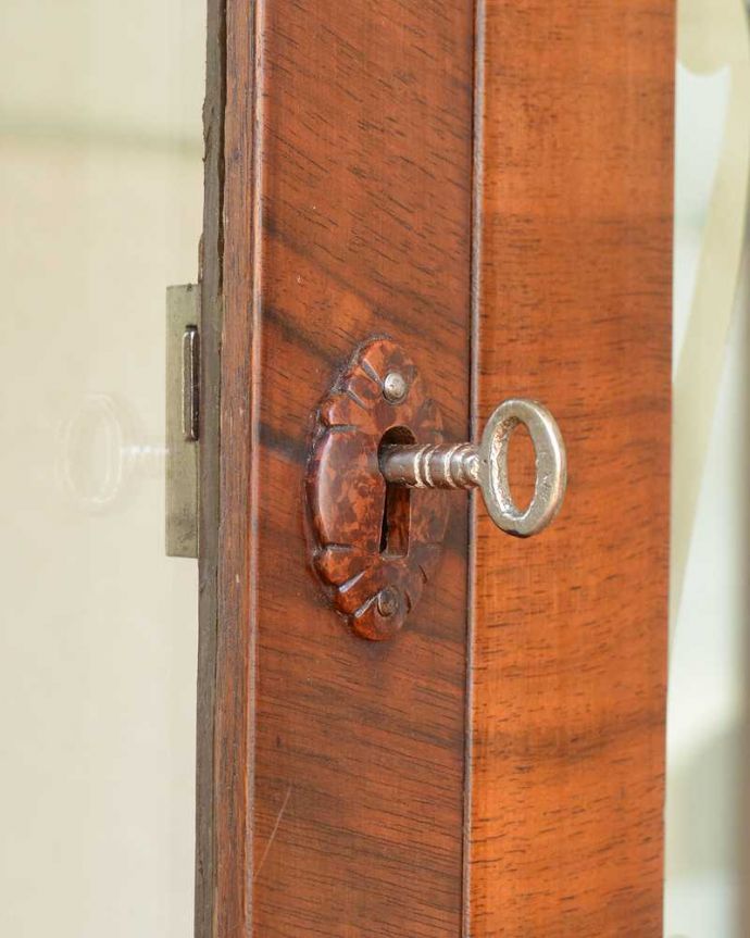 アンティークのキャビネット　アンティーク家具　英国輸入のアンティーク家具、ガラスの装飾も美しいミラー付きガラスキャビネット。開ける度にワクワクする取っ手鍵が取っ手になっているので、中を開ける度にまるで宝箱を開ける気分です。(k-2379-f)