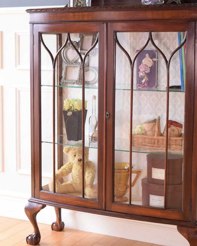 アンティークのキャビネット アンティーク家具 正統派の英国アンティークキャビネット、ゴシックデザインの定番ガラスキャビネット 。ガラス越しに見るお気に入りの美しさ…光をたっぷり取り入れてくれるガラス扉と棚板。(k-2396-f)