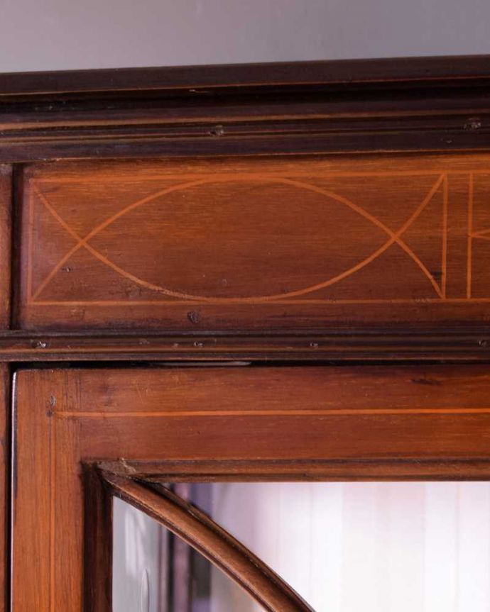 アンティークのキャビネット　アンティーク家具　象嵌入りの美しい英国家具、マホガニー材が美しいアンティークのガラスキャビネット。上品で美しい象嵌象嵌とは模様に沿って異なる木材を埋め込んで絵を描いたものなんです。(k-2568-f)