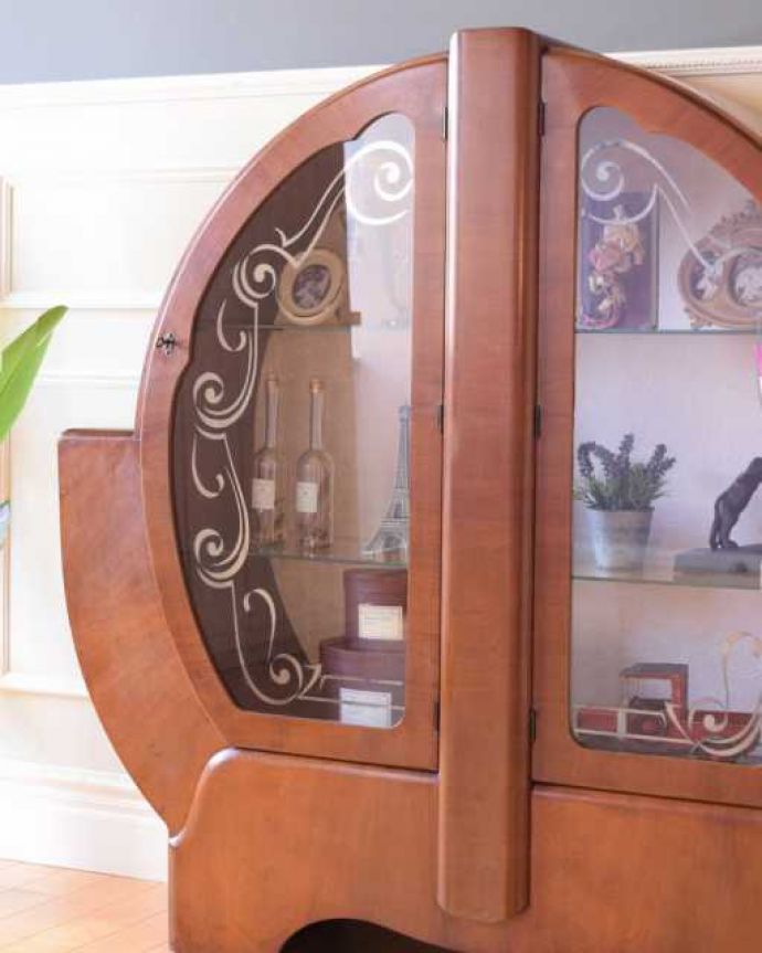 アンティークのキャビネット　アンティーク家具　大人気のアールデコのフォルムが珍しい英国アンティークのキャビネット。ガラスに描かれたキラキラ輝く絵キラキラに輝く絵が描かれたガラス扉越しに中をのぞくと、中に入れたものが全部が宝物に見えてきます。(k-2591-f)