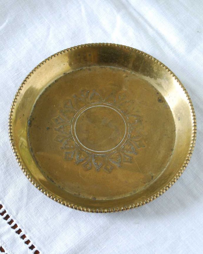 アンティーク 真鍮の雑貨 アンティーク雑貨 英国からのアンティーク雑貨、真鍮の丸いプレート(トレイ)。上から見るとこんな感じですアンティークは新品ではなので多少のキズ・汚れがある場合がありますが、使用上問題はありませんので、ご了承下さい。(k-2605-z)