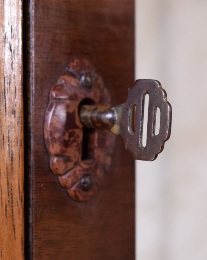 アンティークのキャビネット アンティーク家具 英国アンティークの家具、ガラスの模様がキラキラ輝くガラスキャビネット(飾り棚) 。開ける度にワクワクアンティークらしくカギが取っ手の代わり。(k-2732-f)