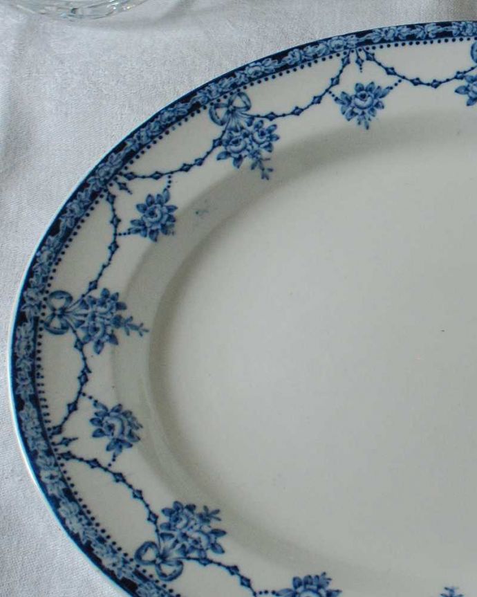 アンティーク 陶磁器の雑貨　アンティーク雑貨　リボンとお花のガーランド模様が描かれたアンティークのフィッシュプレート 。もともとお魚料理のために作られたプレートオーバル型で少し深めのものは、お魚を盛り付けるために作られたフィッシュプレートと呼ばれるお皿。(k-3251-z)
