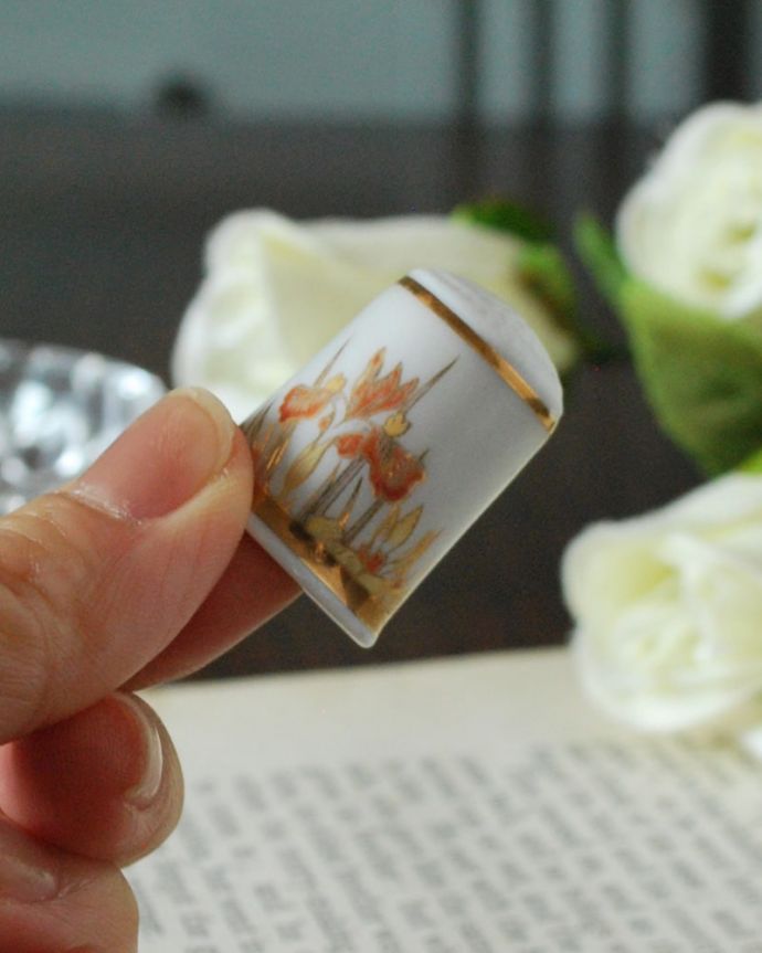 アンティーク 陶磁器の雑貨　アンティーク雑貨　オレンジのお花と蝶が舞うイギリスのアンティークシンブル。コレクションしたくなる可愛らしさ指の帽子（finger hat)とも呼ばれるコロンとした形。(m-3924-z)