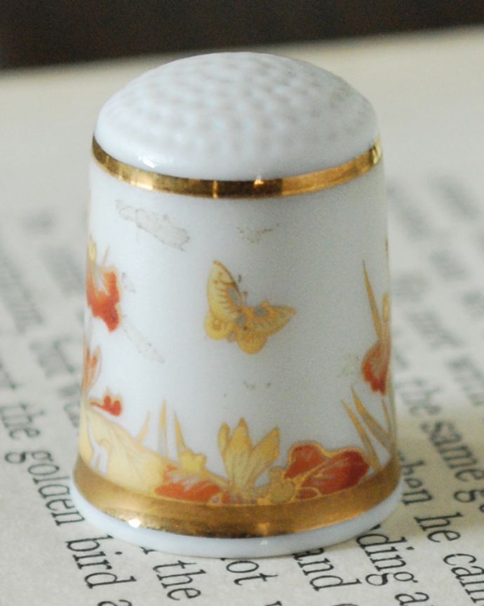 アンティーク 陶磁器の雑貨　アンティーク雑貨　オレンジのお花と蝶が舞うイギリスのアンティークシンブル。幸運を呼ぶ女性のためのコレクションアイテムシンブルとは、上流階級の女性がたしなみとして行ったお裁縫の時に使った指ぬきのこと。(m-3924-z)