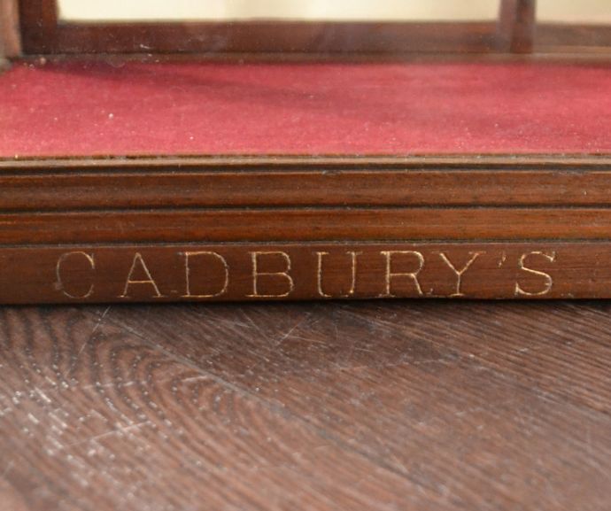 ウォールキャビネット　アンティーク家具　Ｃａｄｂｕｒｙ社のディスプレイキャビネット、アンティークショーケース。「ＣＡＤＢＵＲＹ’Ｓ　ＣＨＯＣＯＬＡＴＥ」の金彩文字が刻まれています。(m-527-f)