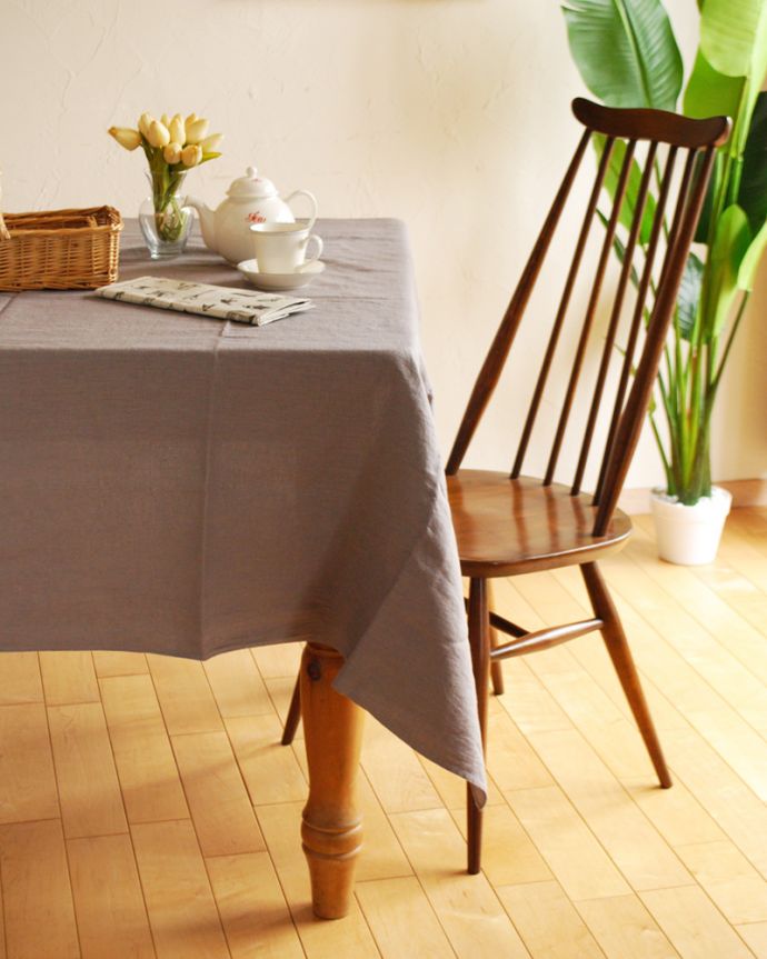 リネンのテーブルクロスを敷いた天然木のダイニングテーブル
