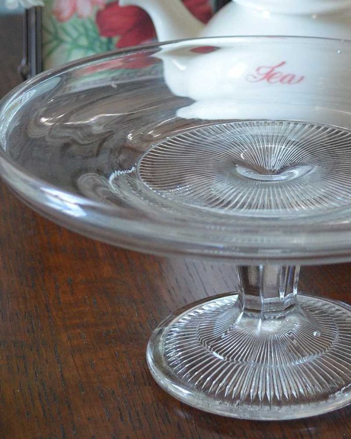 アンティーク 雑貨のガラス小物 アンティーク雑貨 シンプルなラインが美しいガラスのコンポート、ケーキスタンド(プレスドグラス)。センターピースとして使われた器脚が付いているケーキスタンドは、テーブルコーディネイトの中心として食卓の真ん中で華を添えるセンターピースとして使われていました。(pg-4221)