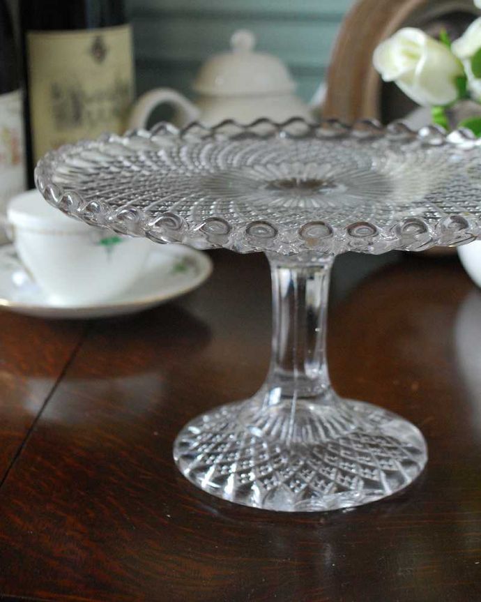 アンティーク 雑貨のガラス小物　アンティーク雑貨　レースのカットのケーキスタンド アンティークプレスドグラス。センターピースとして使われた器脚が付いているケーキスタンドは、テーブルコーディネイトの中心として食卓の真ん中で華を添えるセンターピースとして使われていました。(pg-4888)