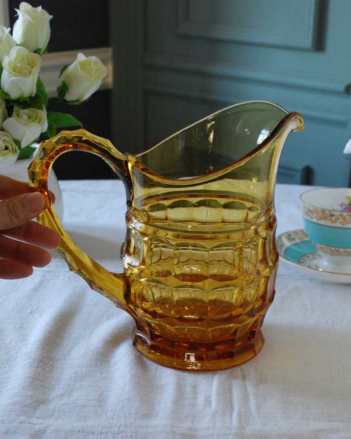 アンティーク 雑貨のガラス小物　アンティーク雑貨　透き通るアンバーカラーが上品なアンティークプレスドグラスのピッチャー（ウォータージャグ）。いろんな使い方が出来ます飲み物を入れるのはもちろんフラワーベースとしても使いやすい便利なサイズです。(pg-5435)