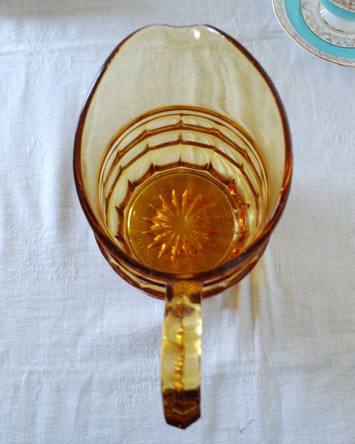 アンティーク 雑貨のガラス小物　アンティーク雑貨　透き通るアンバーカラーが上品なアンティークプレスドグラスのピッチャー（ウォータージャグ）。中を見てみると･･･アンティークなので多少のキズやカケがありますが使用上問題がないものだけをご紹介しています。(pg-5435)