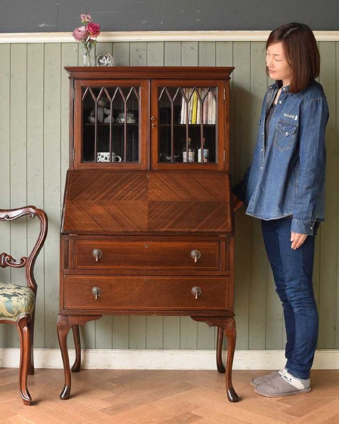 ビューロー アンティーク家具 英国輸入のアンティーク家具、木の装飾も木目の模様も美しいビューローブックケース 。飾り棚とパソコンスペース、両方欲しい方にオススメなのが、このブックケースビューロー!(モデルの身長は165cmです)。(q-1037-f)