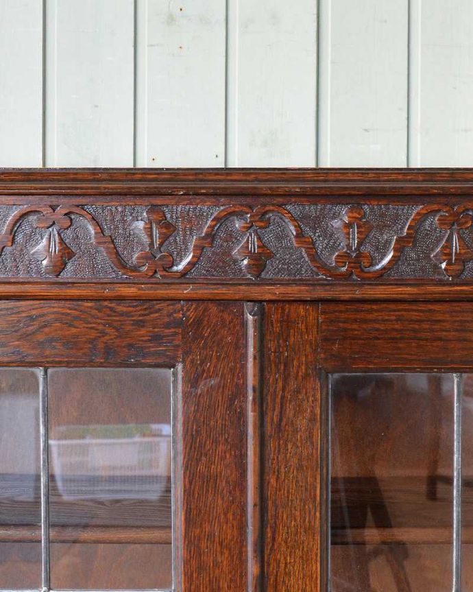 アンティークのキャビネット　アンティーク家具　ステンドグラスをはめ込んだブックケース（本棚）、アンティーク英国家具。天板の周りには彫りがいっぱいで豪華なデザインになってます。(q-1226-f)