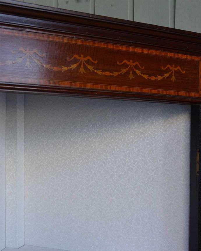 アンティークのキャビネット　アンティーク家具　お部屋の角を彩るアンティーク家具、ガラス扉のシノワズリデザインのコーナーキャビネット。新しく貼り替えましたキャビネットの表情に合わせて、背板の生地をセレクト。(q-1244-f)