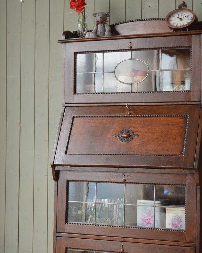ビューロー　アンティーク家具　ガラスにステンドグラスがはめ込まれたアンティークのビューローブックケース。英国アンティークらしいガラス扉の美しさデスクの上はガラス扉のキャビネット。(q-1381-f)
