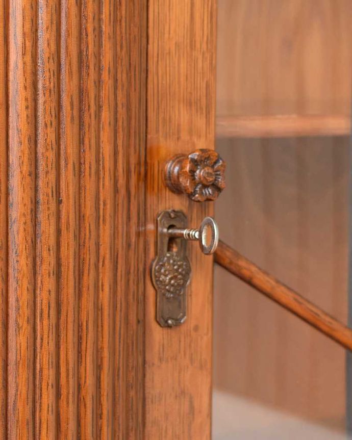 アンティークのキャビネット　アンティーク家具　華やかなアンティークの英国家具、お花の彫刻入りのブックケース（本棚） 。小さなパーツにもこだわり取っ手だけを見ていても現代とは違って良質な素材が使われているのが分かります。(q-1389-f)