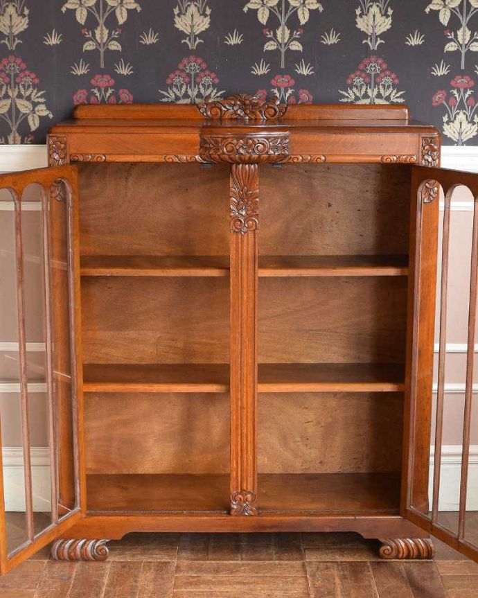 アンティークのキャビネット　アンティーク家具　英国輸入のアンティークの収納家具、お花の彫刻入りのブックケース（キャビネット）。扉を開けると･･･重い本がたっぷり収納できるように頑丈に作られています。(q-1413-f)