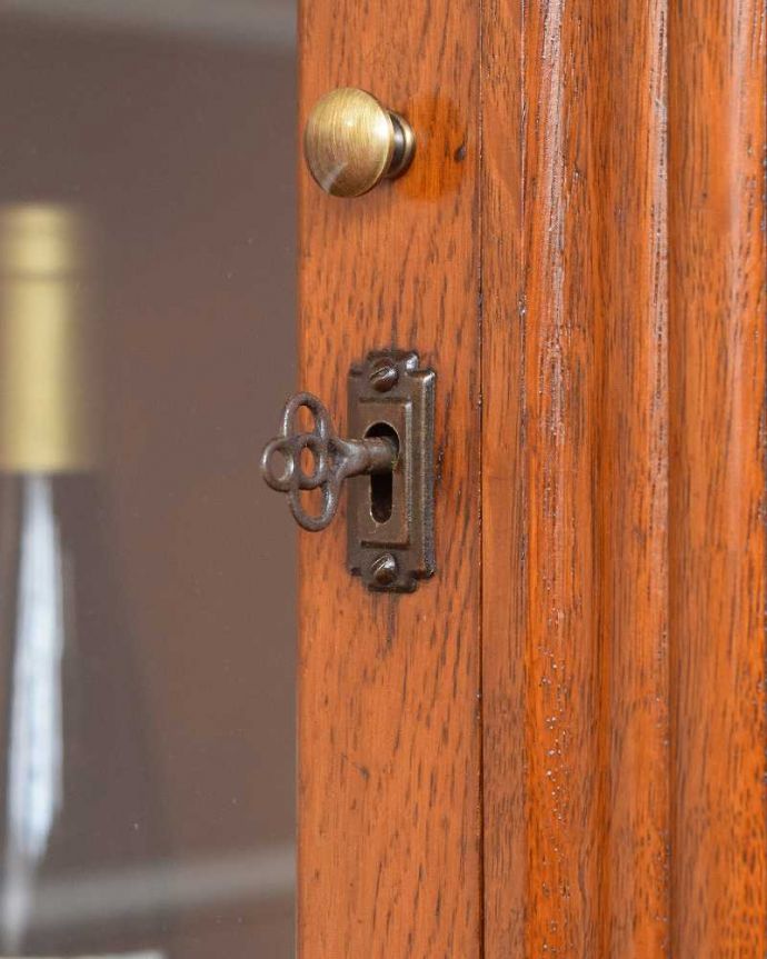 アンティークのキャビネット　アンティーク家具　英国輸入のアンティークの収納家具、お花の彫刻入りのブックケース（キャビネット）。小さなパーツにもこだわり取っ手だけを見ていても現代とは違って良質な素材が使われているのが分かります。(q-1413-f)