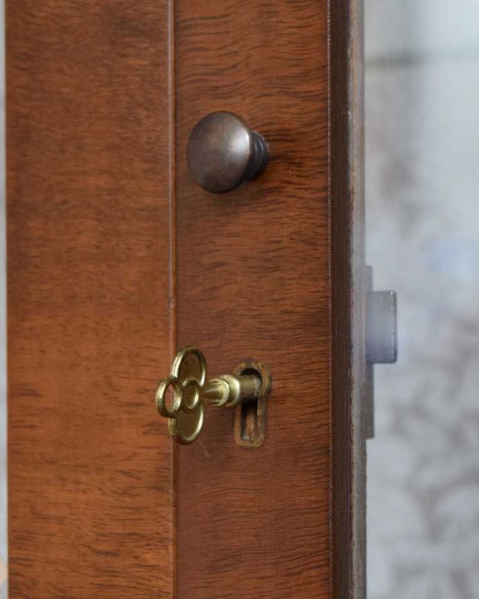 アンティークのキャビネット　アンティーク家具　美しいガラス扉のアンティーク家具、英国輸入のガラスキャビネット（飾り棚） 。開ける度にワクワクする取っ手鍵が取っ手になっているので、中を開ける度にまるで宝箱を開ける気分です。(q-1445-f)