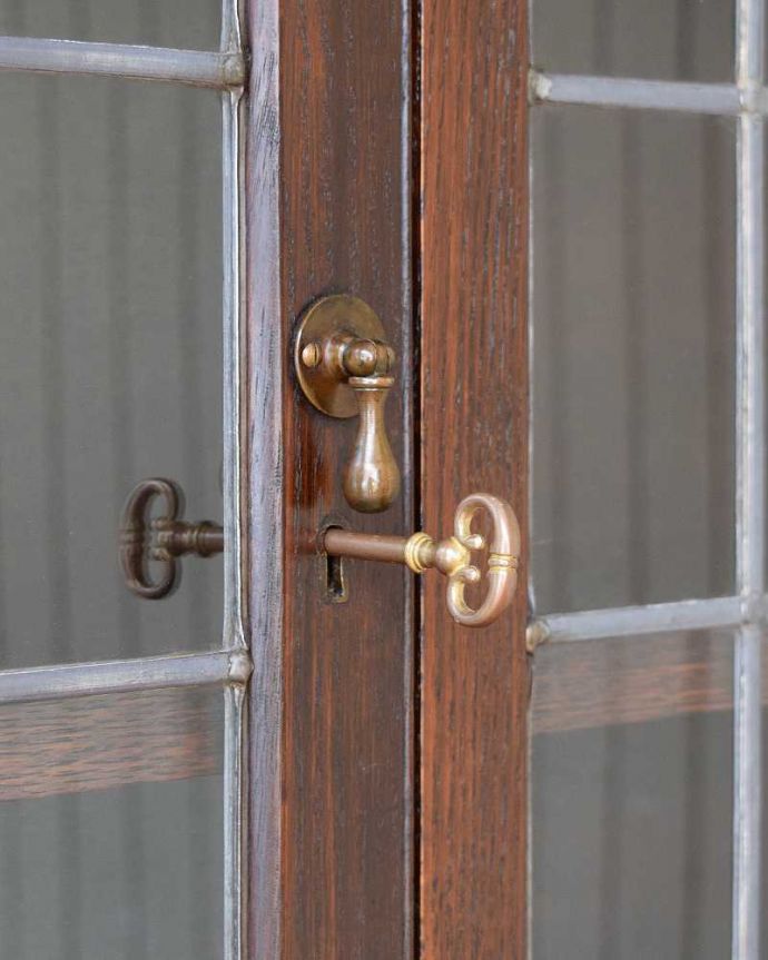 アンティークのキャビネット　アンティーク家具　和室にも似合うアンティークの英国家具、英国紳士たちが愛したガラス扉のブックケース（本棚）。開ける度にワクワク･･･取っ手もアンティークらしいデザイン。(q-1469-f)