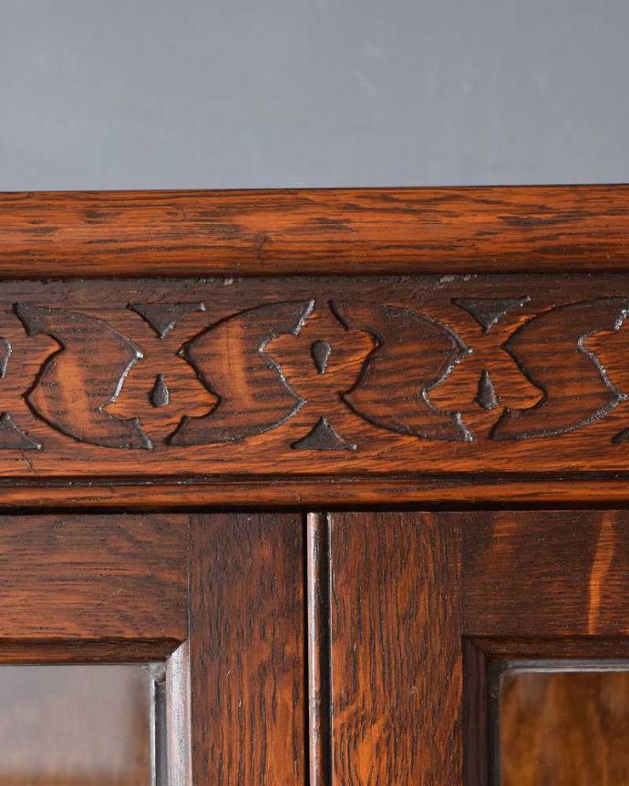 アンティークのキャビネット　アンティーク家具　美しい英国アンティーク家具、ガラス扉がお洒落なブックケース（ガラスキャビネット）。惚れ惚れする彫の美しさこんなに堅い無垢材に一体どうやって彫ったんだろう？と不思議になるくらいアンティークらしく細かい彫りは眺めているだけでうっとりする美しさです。(q-1488-f)