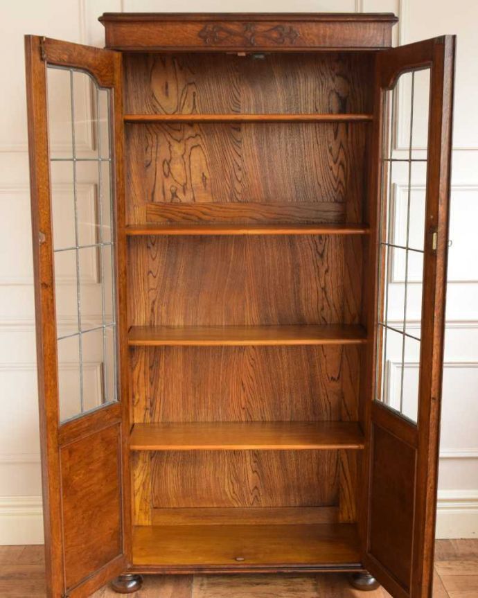 アンティークのキャビネット アンティーク家具 美しいガラス扉のアンティーク家具、飾り棚にもなるアンティークブックケース (キャビネット)。扉の中は、しっかりと収納できる棚板重いものもたっぷり収納できる木製の棚板タイプ。(q-1580-f)
