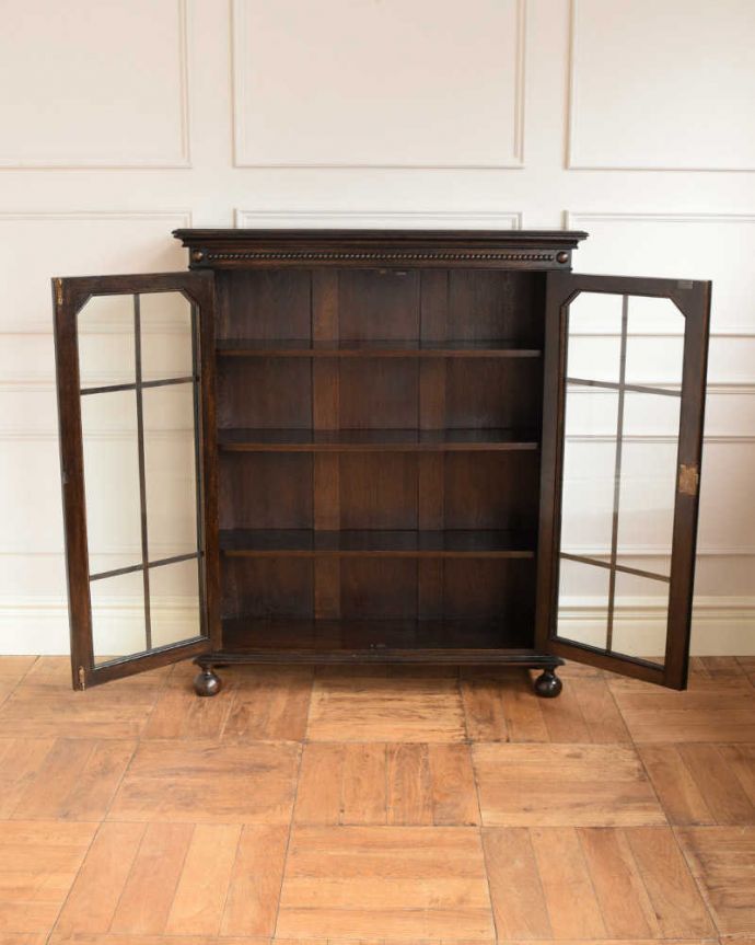 アンティークのキャビネット アンティーク家具 アンティーク英国家具、ガラス扉のかっこいい落ち着いた色のブックケース(本棚) 。扉の中は、しっかりと収納できる棚板重いものもたっぷり収納できる木製の棚板タイプ。(q-1653-f)