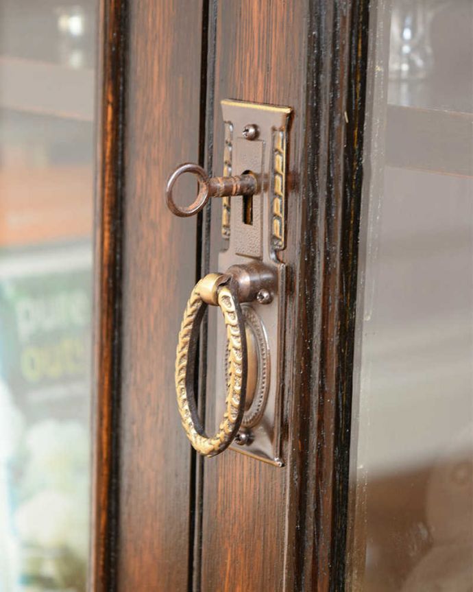 アンティークのキャビネット アンティーク家具 アンティーク英国家具、ガラス扉のかっこいい落ち着いた色のブックケース(本棚) 。英国らしいドッシリ感アンティーク家具は取っ手もカッコイイんです。(q-1653-f)