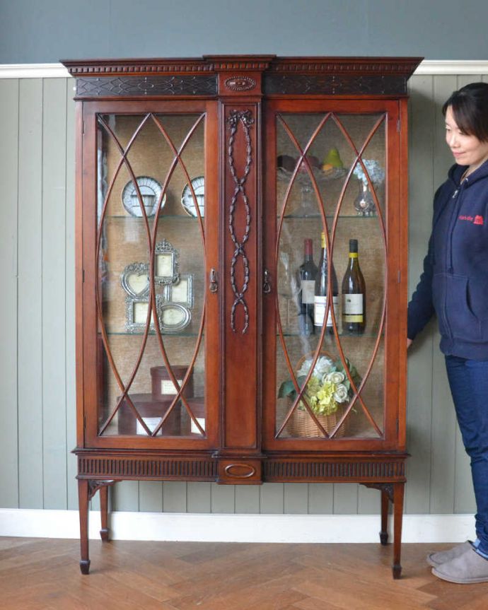 アンティークのキャビネット　アンティーク家具　アンティークの大きな英国家具、リボンの装飾が優雅なガラスキャビネット（ショーケース）。眺めているだけで幸せ･･･芸術的に美しいディスプレイキャビネットは、置くだけで周りの空気を変えてくれます。(q-1677-f)