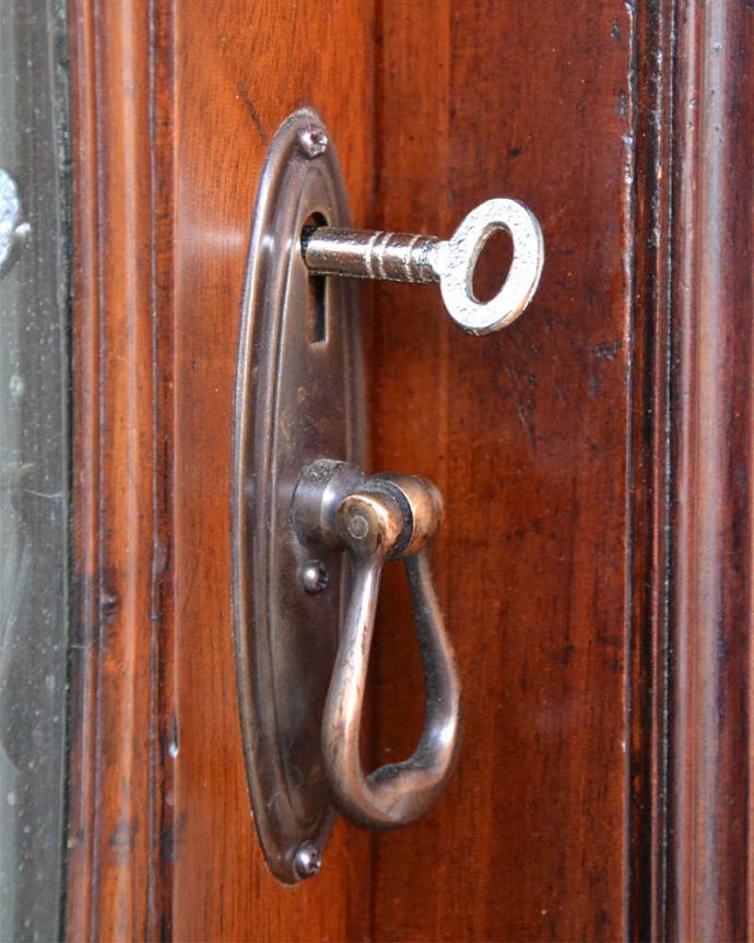 アンティークのキャビネット　アンティーク家具　アンティークの大きな英国家具、リボンの装飾が優雅なガラスキャビネット（ショーケース）。開ける度にワクワク取っ手もアンティークらしいデザイン。(q-1677-f)