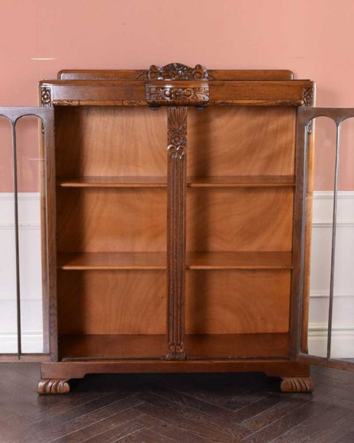 アンティークのキャビネット　アンティーク家具　花の彫りが華やかなアンティークの英国家具、鍵付きのブックケース（本棚）。扉の中は、しっかりと収納できる棚板重いものもたっぷり収納できる木製の棚板タイプ。(q-1685-f)