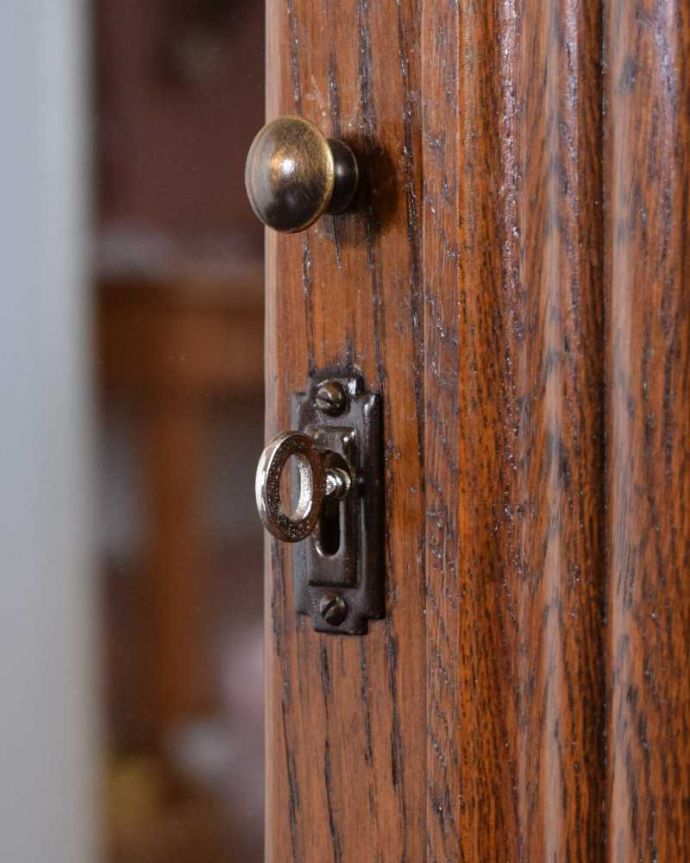 アンティークのキャビネット　アンティーク家具　花の彫りが華やかなアンティークの英国家具、鍵付きのブックケース（本棚）。小さなパーツにもこだわり取っ手だけを見ていても現代とは違って良質な素材が使われているのが分かります。(q-1685-f)