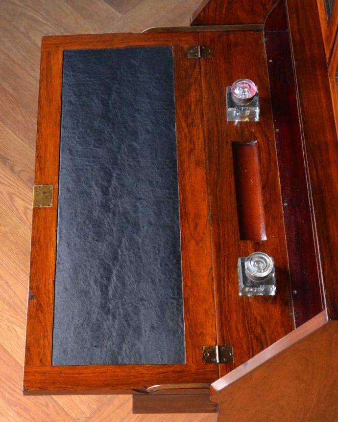 ビューロー アンティーク家具 象嵌が装飾された豪華なアンティーク家具、ミラー付きアンティークビューローブックケース。デスクの天板を上から見ると・・・やっぱりデスクは天板部分が気になるから、専門の職人が古い塗装を剥離してピッカピカに修復しました。(q-1691-f)