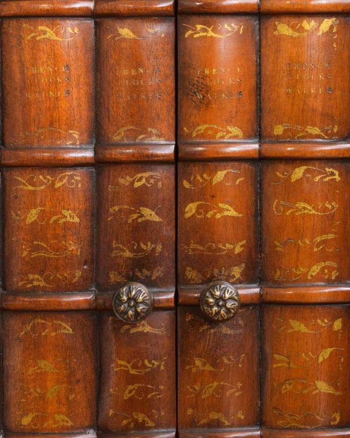 アンティークのキャビネット アンティーク家具 英国で見つけた珍しいサイドキャビネット、どこにでも置けるコンパクトなアンティーク家具。扉は職人のこだわりのデザイン本モチーフの扉が素敵。(q-1696-f)