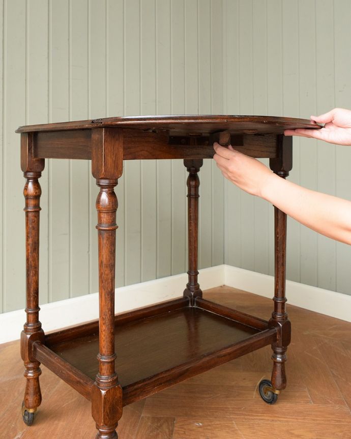 アンティークのワゴン・トローリー アンティーク家具 英国のお洒落で便利なアンティーク家具、サイズが変わる伸張式のワゴン(トロリー)。あっという間に大きくなります天板を持ち上げて下にあるバーを引っぱりだせば、あっという間に大きな作業台に。(q-1844-f)