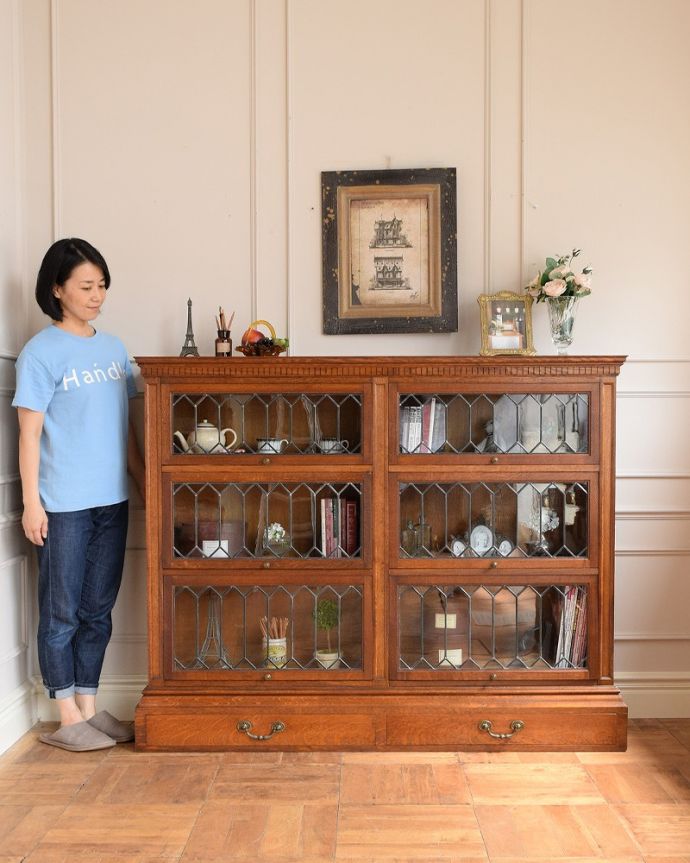 アンティーク家具 美しい格子デザインのガラス扉がキラキラ輝くアンティークの英国家具、フラップ扉のブックケース。ステンドグラスの扉が美しいキャビネット扉がステンドグラスになっているから、キャビネットとステンドグラスの両方を一気に手に入れることが出来ちゃうんです。(q-1852-f)